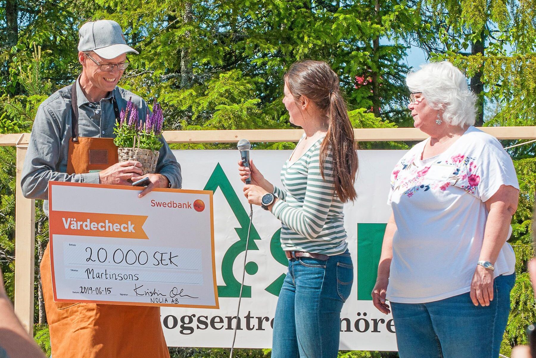 Mats Lindfors, fältchef på Martinsons, tar emot priset för mest jämställda monter på Skogsnolia från Elin Olofsson, Nätverket för Yrkesverksamma Kvinnor i Skogsbranschen, samt Ann Dolling, Skogslänet Västerbotten.