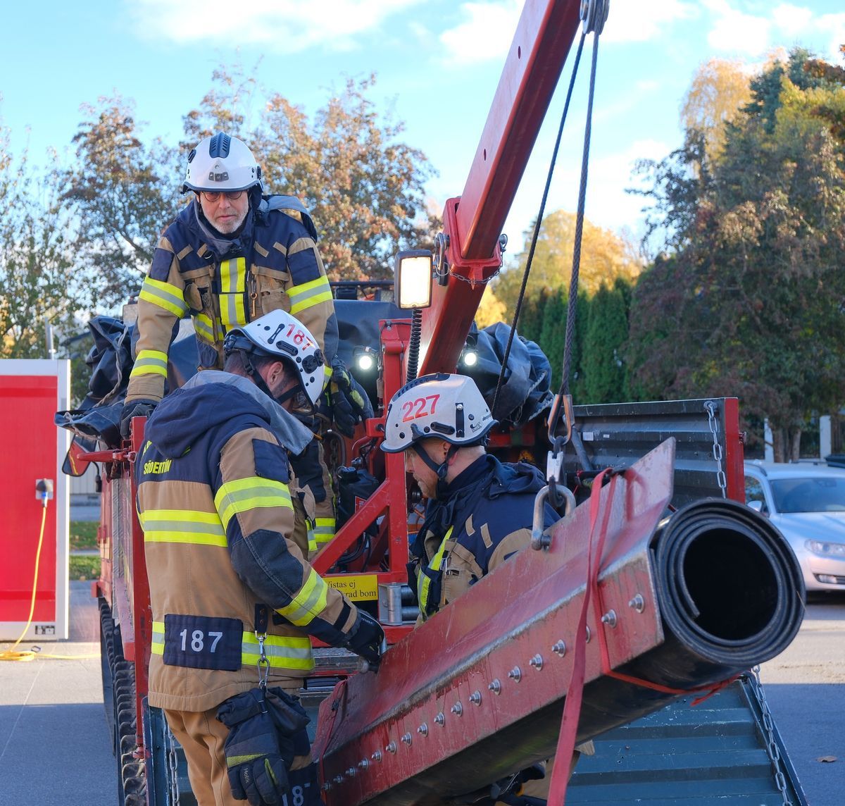 Brandmän tränar med utrustning utomhus.