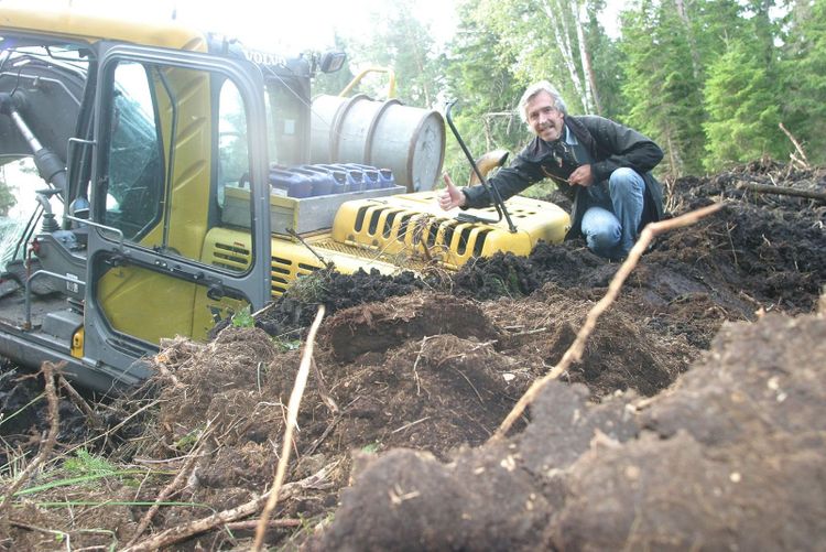 Volvo-grävare som kapsejsat i ett dike.