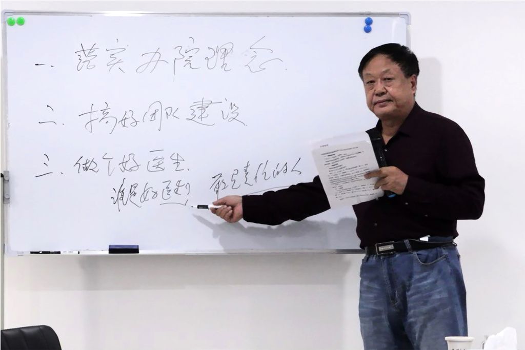 Sun Dawu framför whiteboardtavla, pekar med penna på tavlan. 